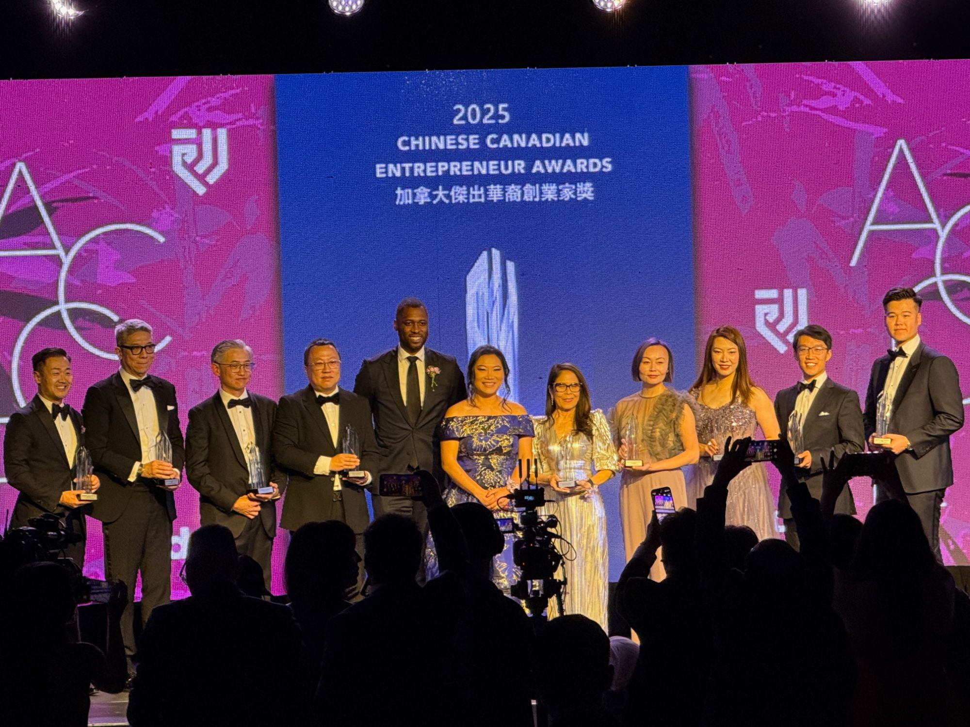 Award recipients on stage in front of an LED backdrop at the Chinese Canadian Entrepreneur Awards